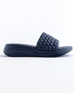 Navy blue slide sandal with textured strap on a white background
